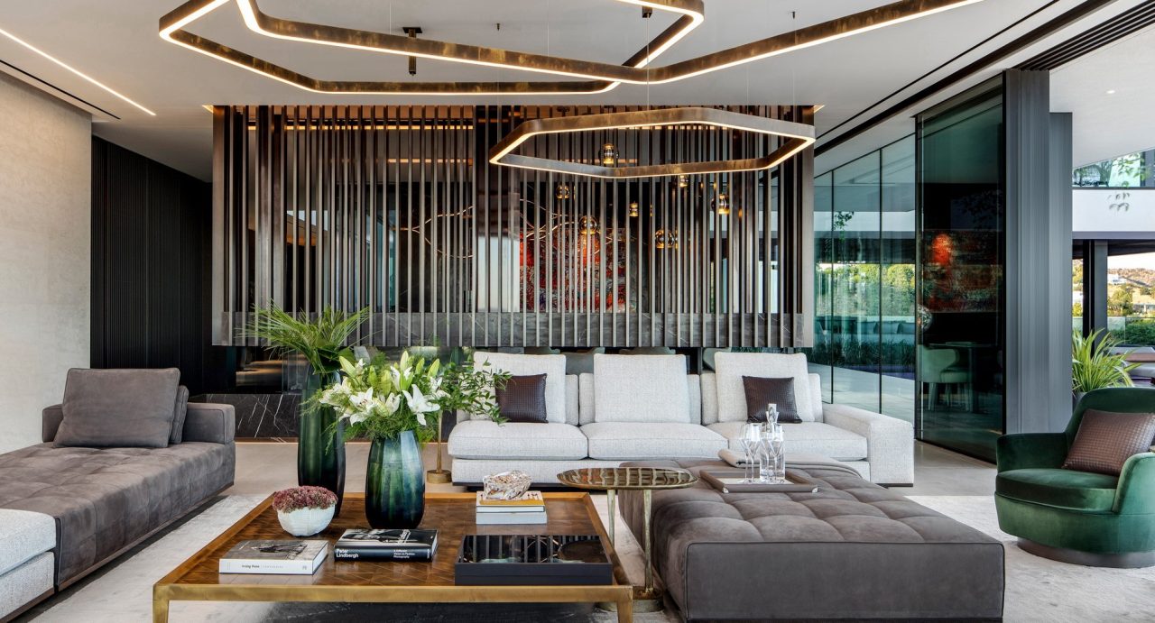 Estate living room with white sofas, a timber slat feature wall and glowing hexagonal ceiling lights
