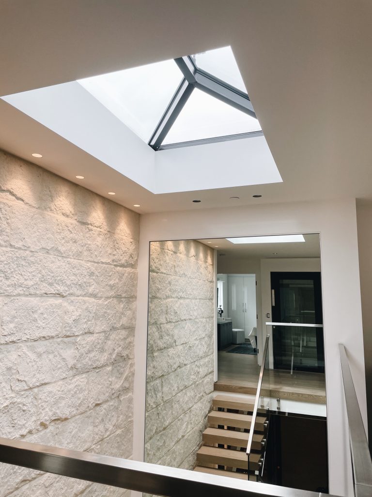 Stone feature wall and skylight above the stairwell at the Newport Beach home