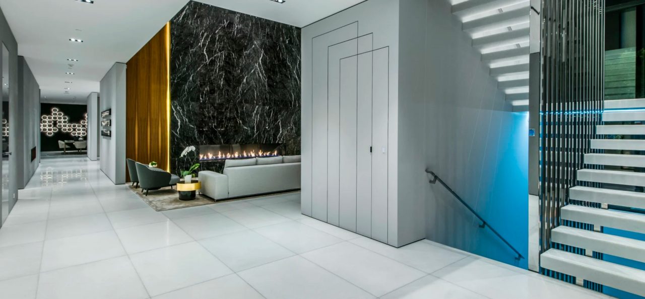 Hallway with a black marble feature wall, a fireplace lounge, floating white stairs and a flush panel door