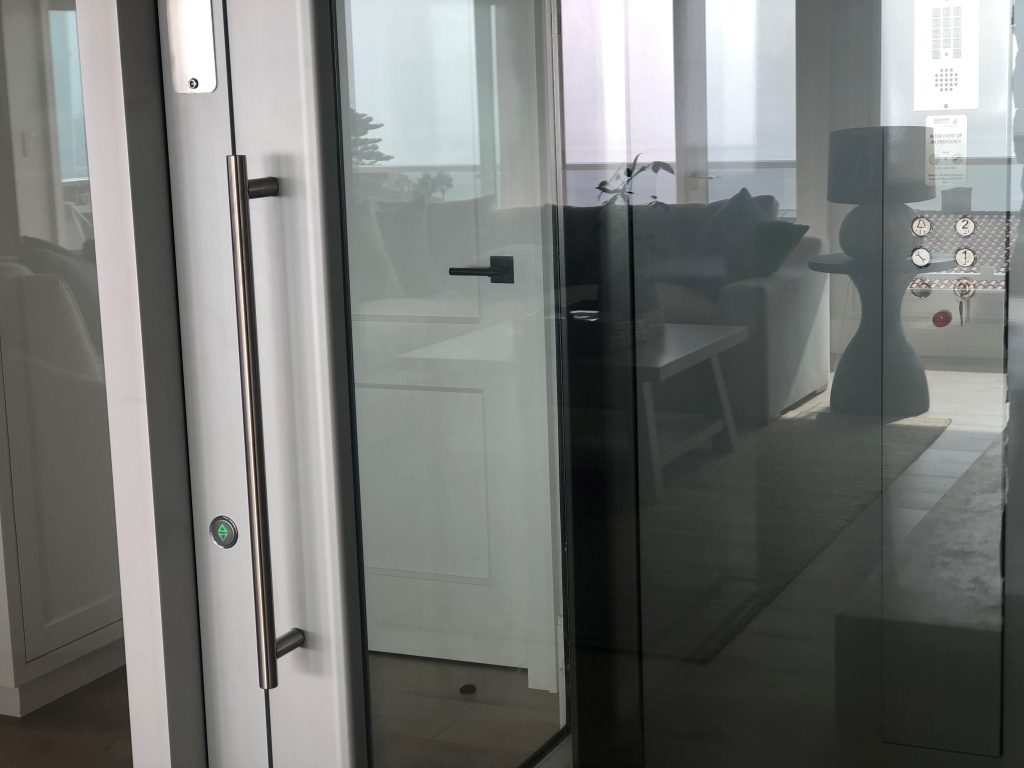 Vertical car operating panel and long door handle on the glass lift door