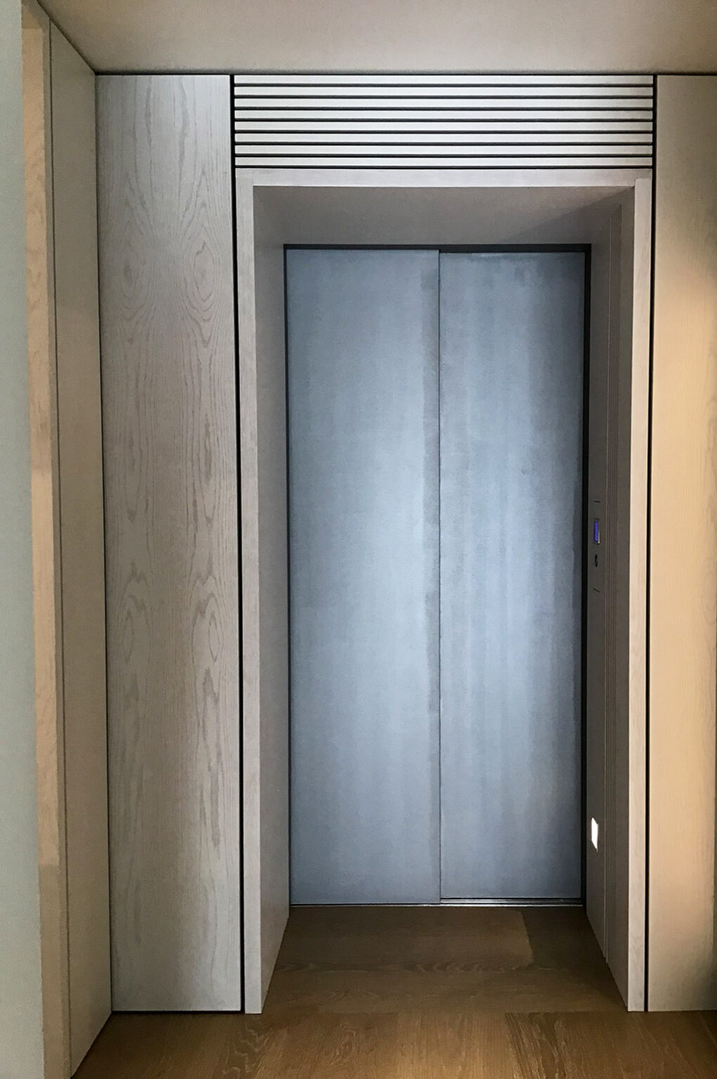 Closed galvanised sliding lift door set in a timber panelled alcove in the Vaucluse home