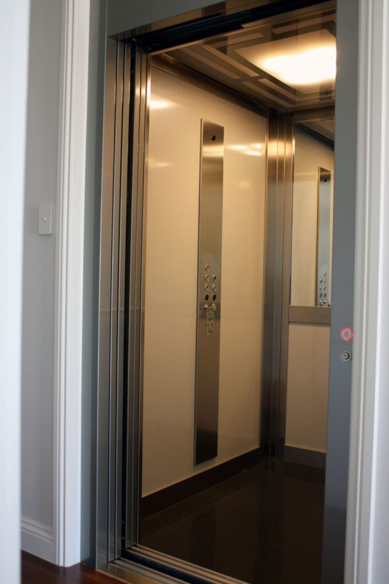 Open lift door showing the stainless steel car operating panel, Grigio wall panels and the Labirint ceiling