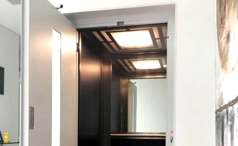 Dark lift interior with patterned ceiling lights seen through an open door in Baulkham Hills