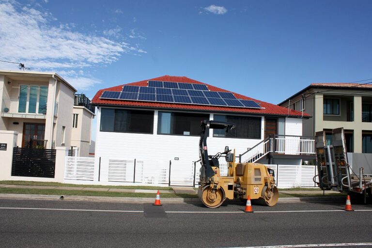 Renovated Queenslander in Shorncliffe with a red tiled roof and solar panels, seen from the street
