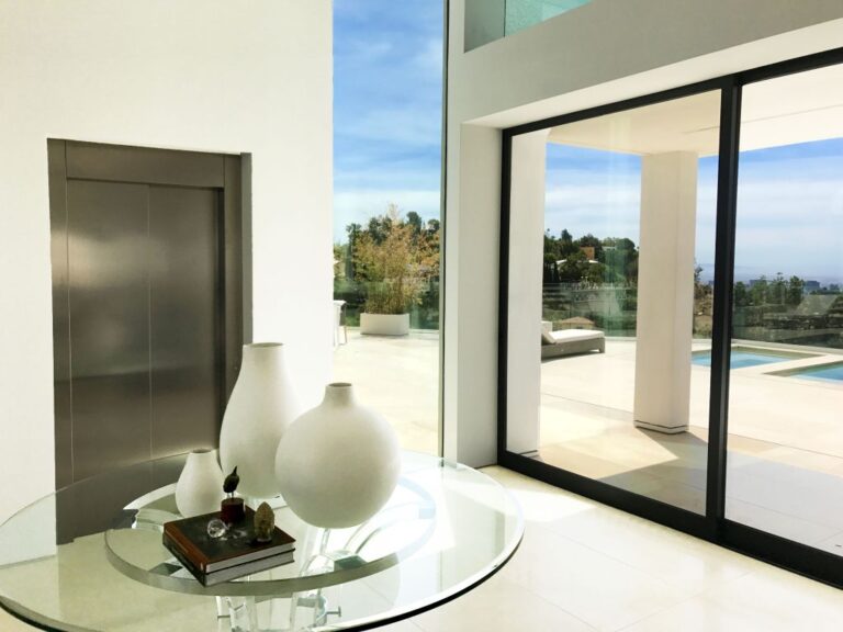 Stainless lift door beside a glass-top table and sliding glass doors in Bel Air