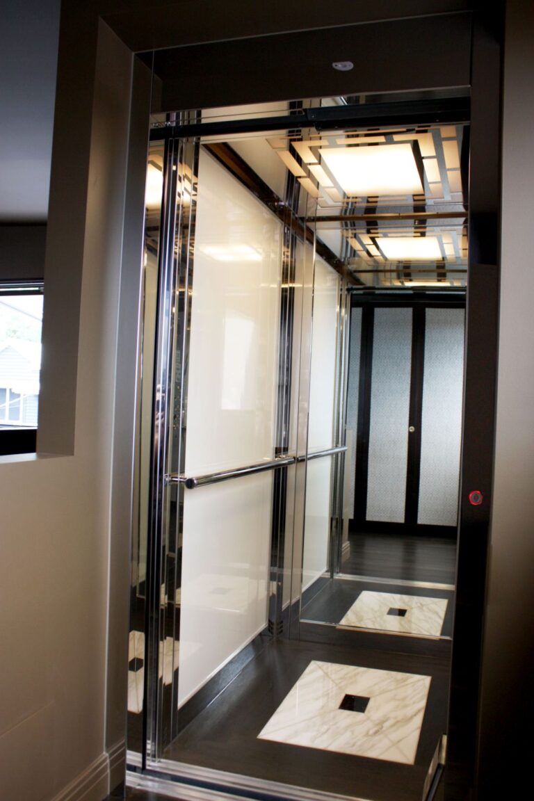 Duplex E2 lift cabin with a stainless handrail and glass doors on both ends