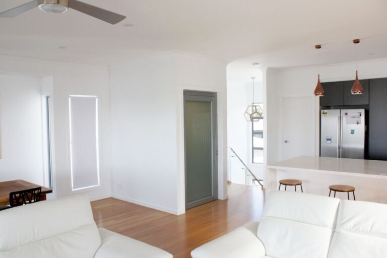 Open plan living area in an Ormiston home with a lift door beside the kitchen