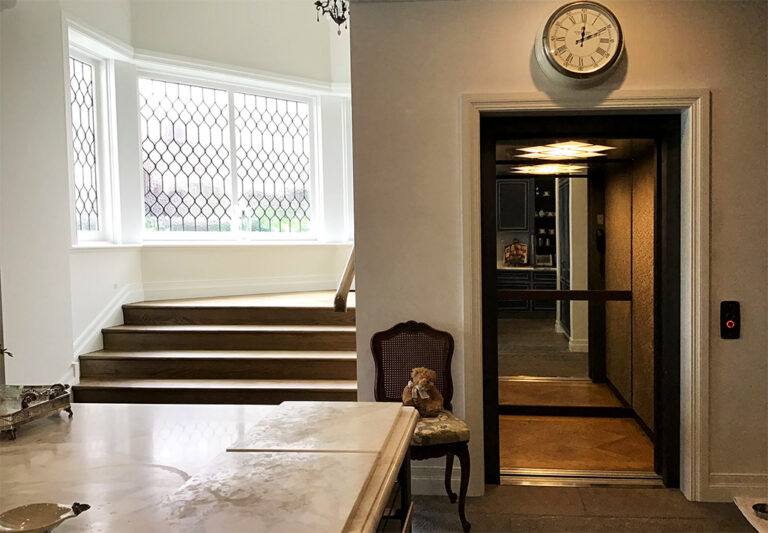Lift doorway at the end of a hall beside steps and a bay window in Sydney