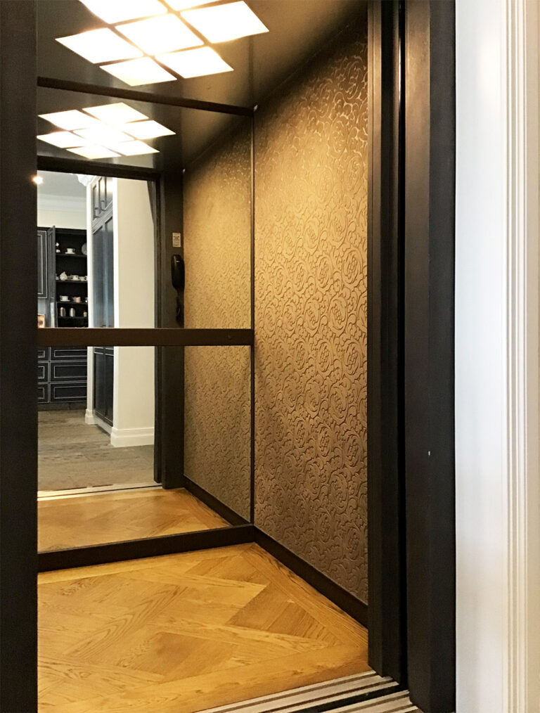 Inside the lift with velvet feature walls, a mirrored panel, parquetry floor and square ceiling lights, Sydney
