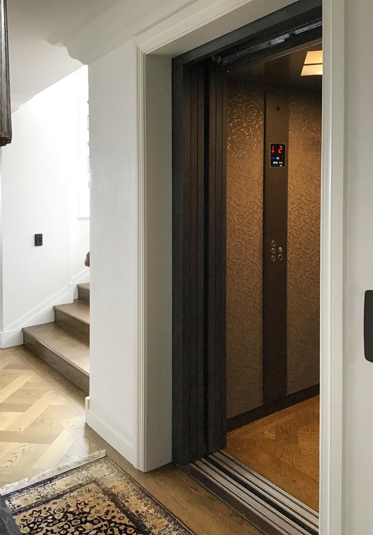 Open lift door showing velvet feature walls beside a timber staircase landing