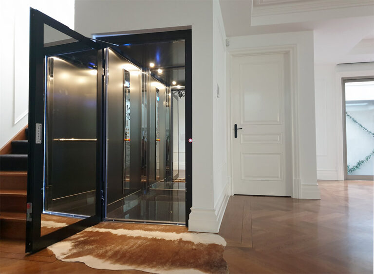 Black-framed swing door home lift opening onto a timber floor in an Eaglemont home