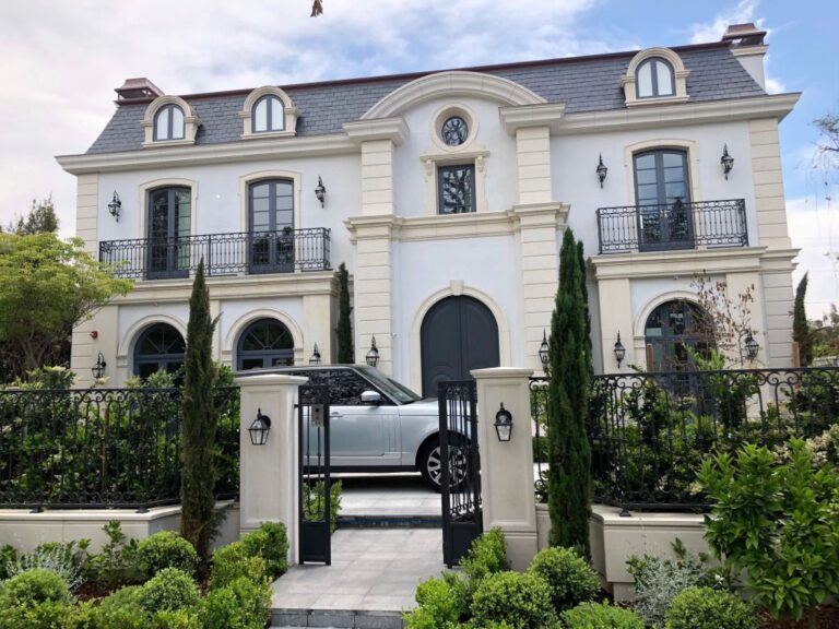 French style two storey home with a slate roof, iron gates and clipped hedges, Beverly Hills