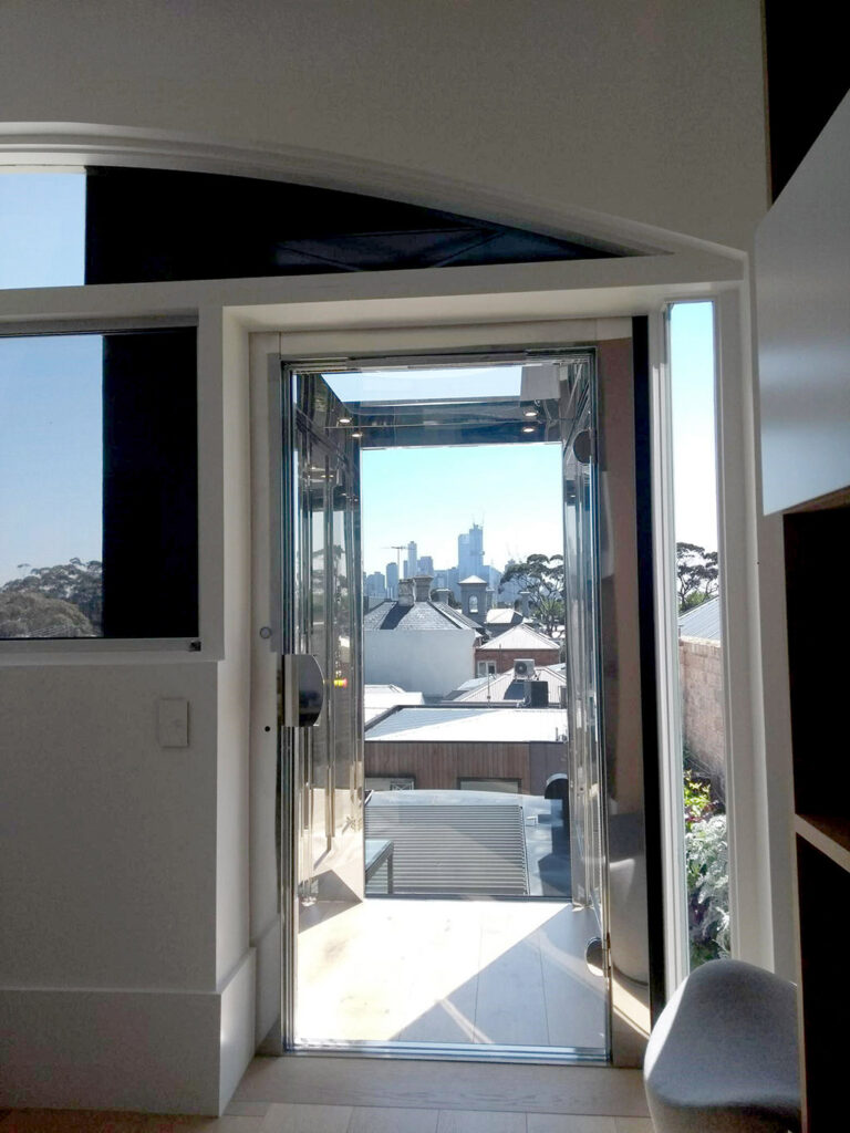 Looking out through the lift car to a city skyline and rooftops