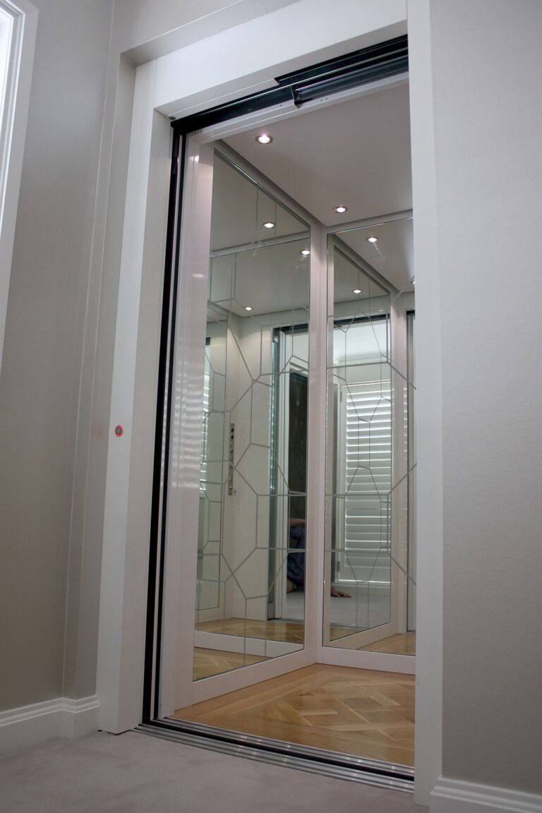 Lift door with mirrored panels reflecting a window with shutters