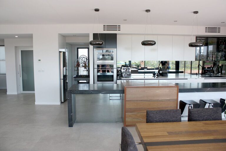 Open-plan kitchen and dining area with a grey benchtop and pendant lights