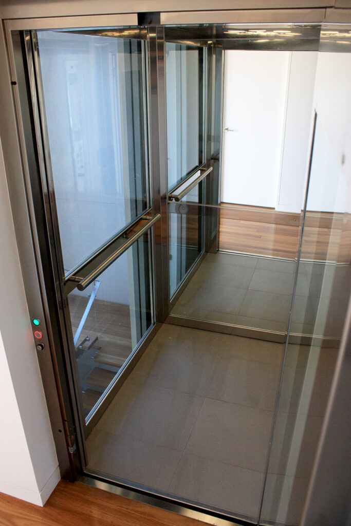 Inside the three-level ElfoLift in Lane Cove, with full-height glass walls, stainless steel handrails and a tiled floor