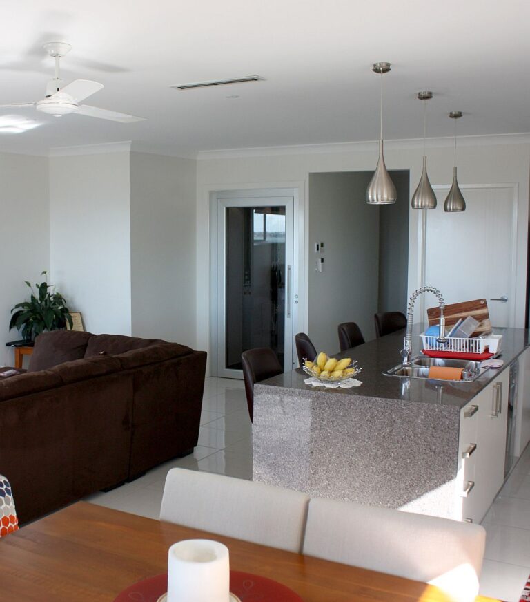 Kitchen and living area with pendant lights and the lift door in the background