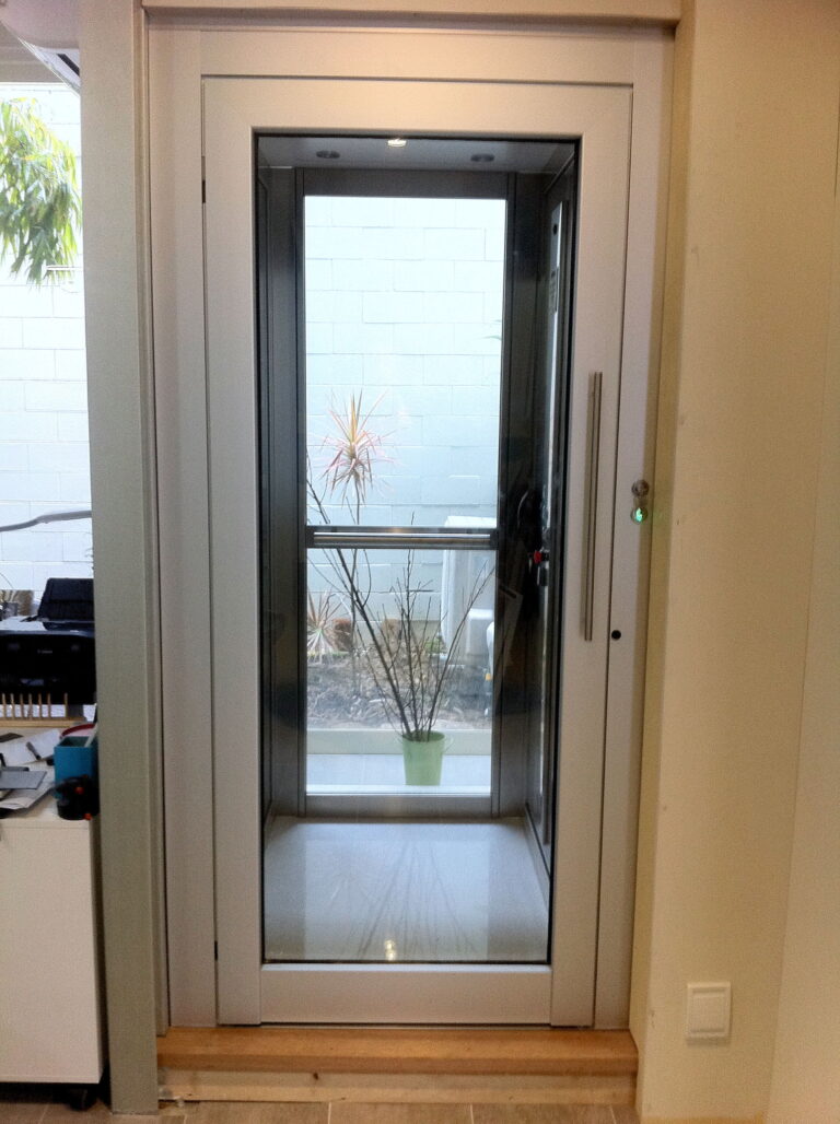 The finished lift landing door with a glass vision panel