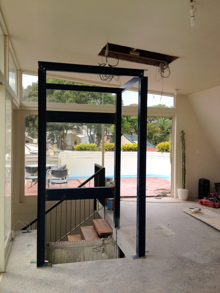 The steel shaft frame rising from the stairwell during the retrofit