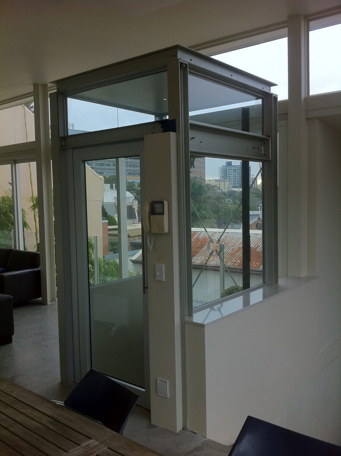 The finished three-stop ElfoLift with a glass shaft, standing where the steel frame went in