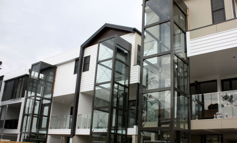 Row of townhouses with glass lift towers on the rear in New Farm
