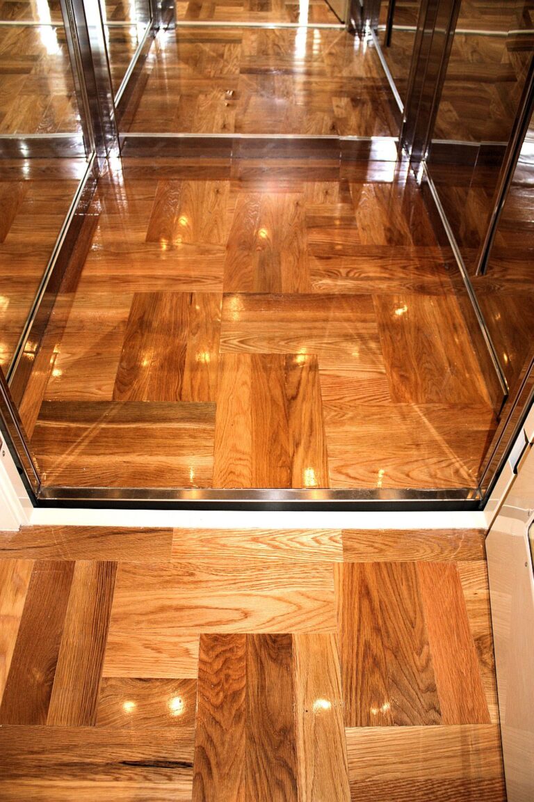 The parquet timber floor laid inside the lift cabin, continuing the pattern of the landing floor outside