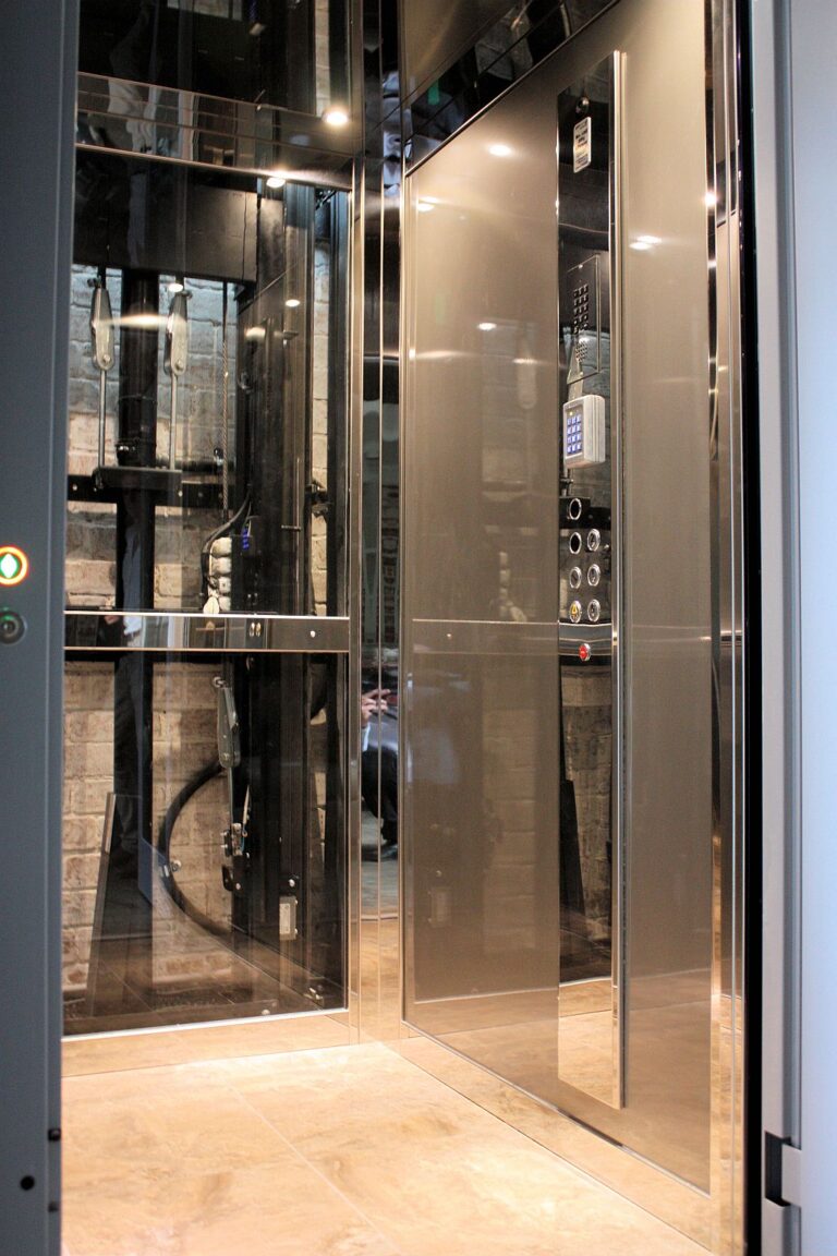 Inside the E1 lift cabin in Collingwood with stainless steel walls, a keypad panel and a stone floor