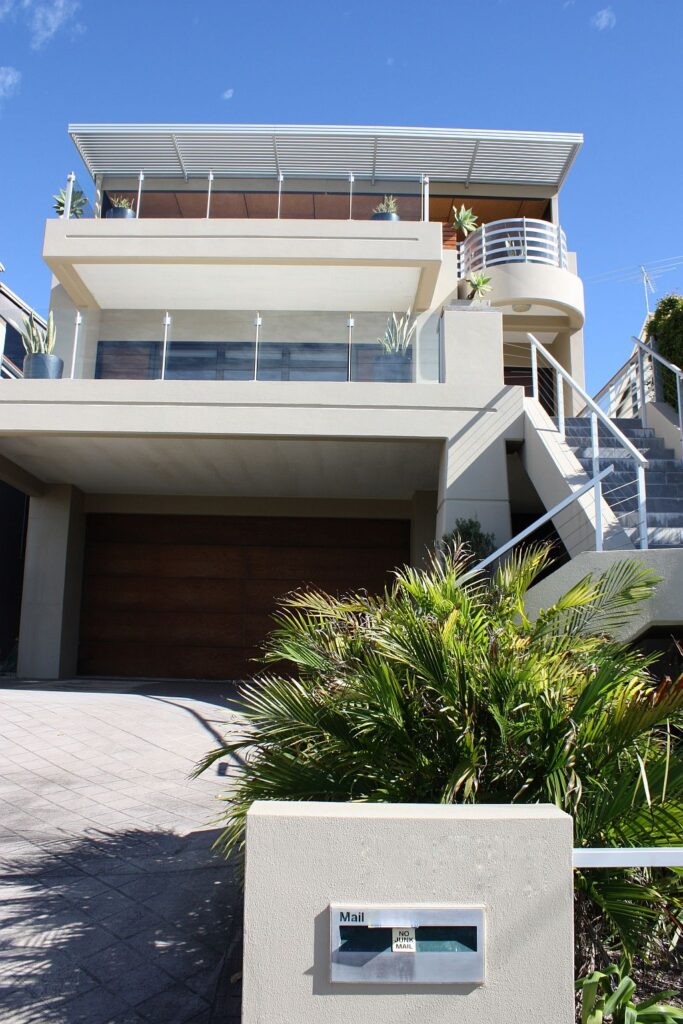 Street frontage of the multi level Bulimba home with timber garage door and letterbox