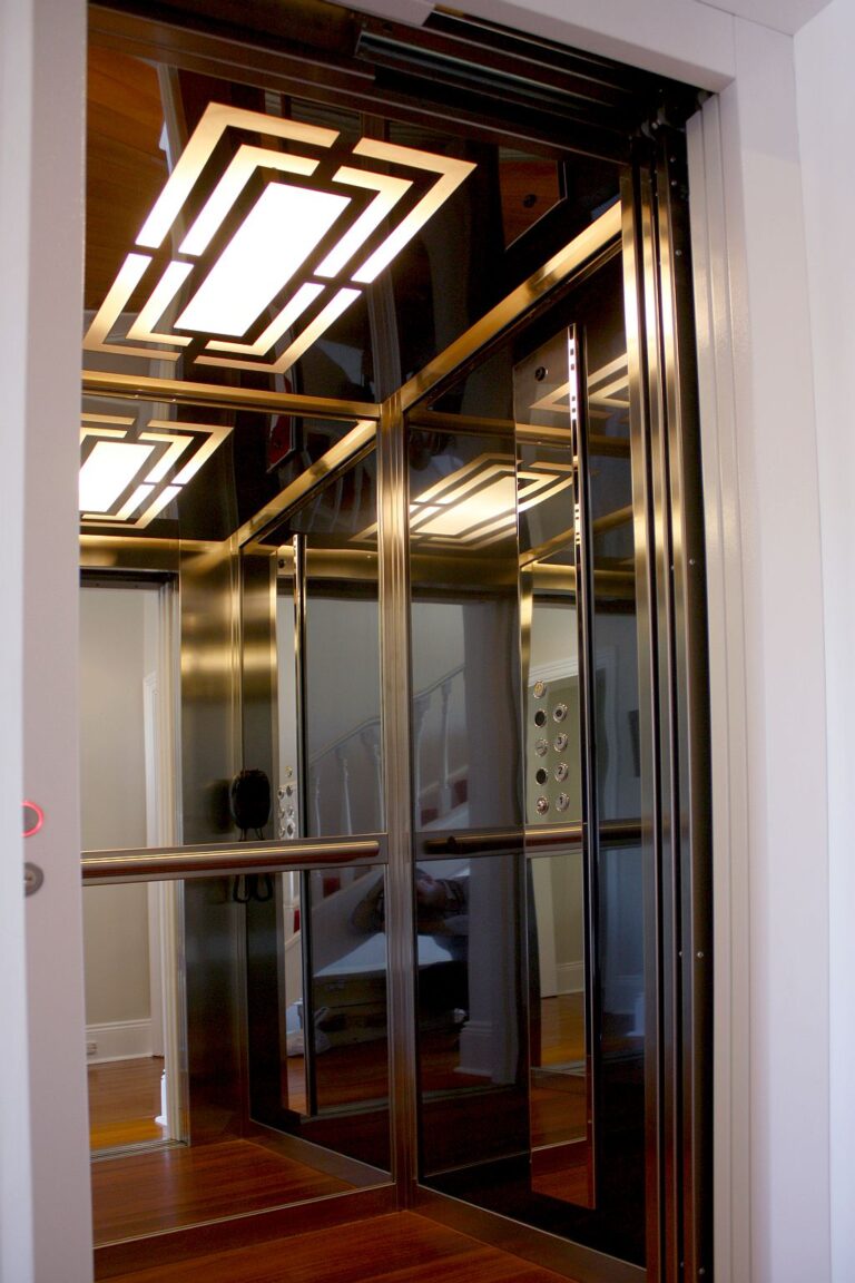 Inside the ElfoLift 2 with black stainless walls, brushed stainless profiles, mirrors and a patterned ceiling light