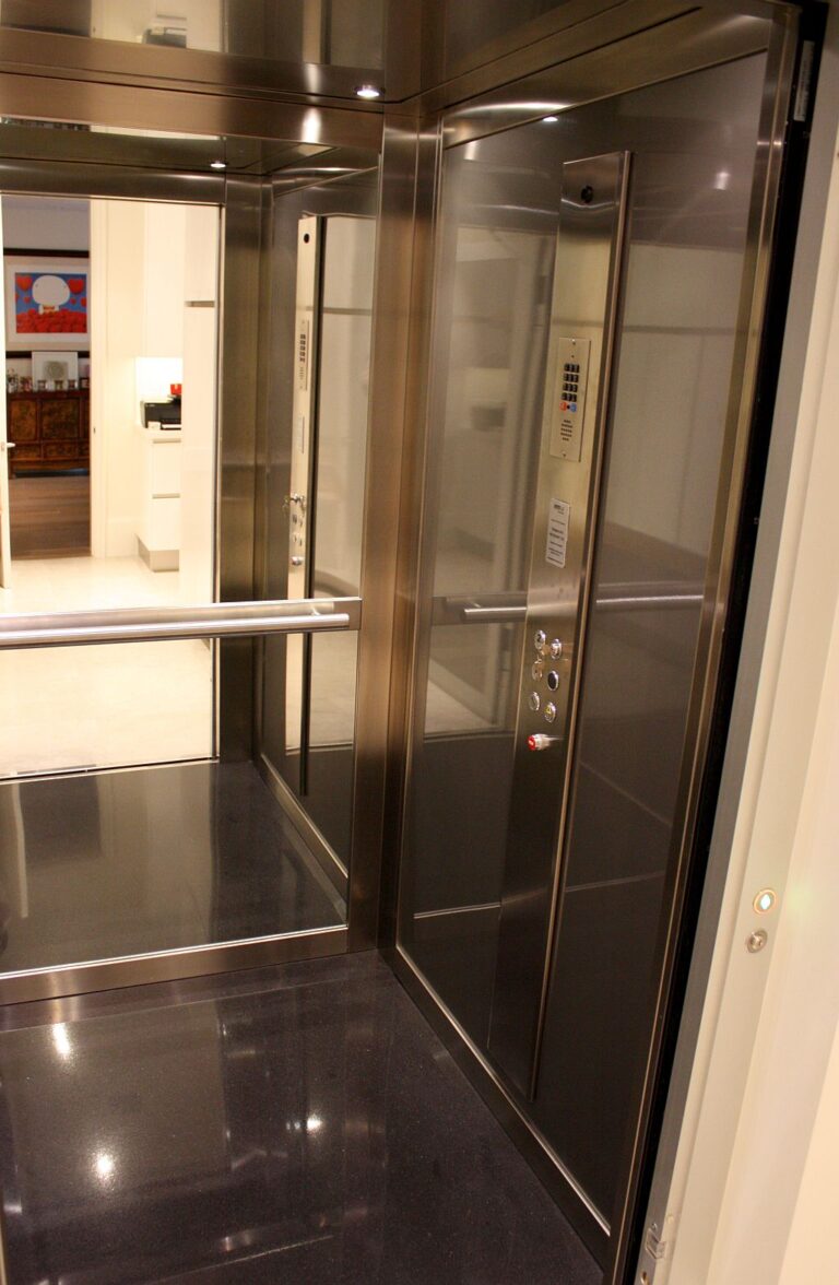 Inside the lift: stainless steel panels, control panel and a glossy black floor