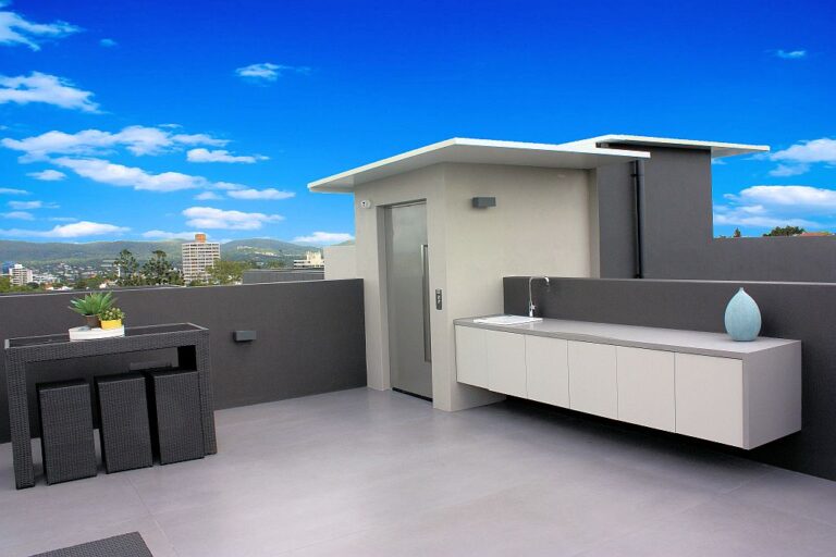 Rooftop terrace with a lift enclosure, outdoor bench and sweeping view over Brisbane