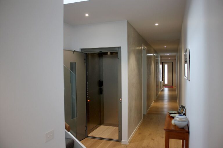 Open ElfoLift door at the end of a long hallway with a timber floor