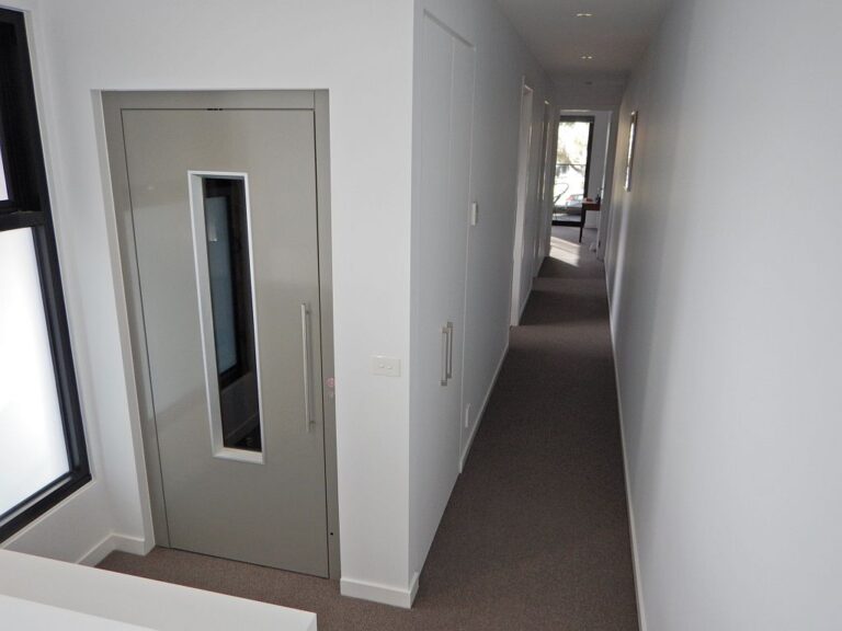 ElfoLift door with a narrow glass slot in a long hallway with carpet