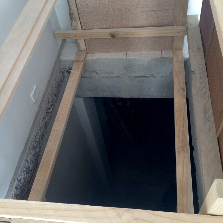 Looking down the timber-framed opening above the dark lift pit during the bones-only shaft build