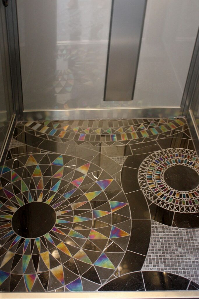 Close view of the hand-cut Italian mosaic tile floor inside the lift