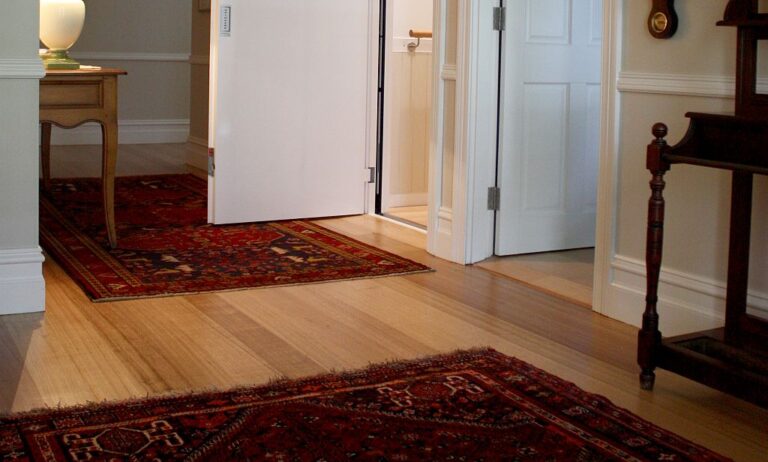 Hallway with a red rug, a side table and open white doors in a Seaforth home