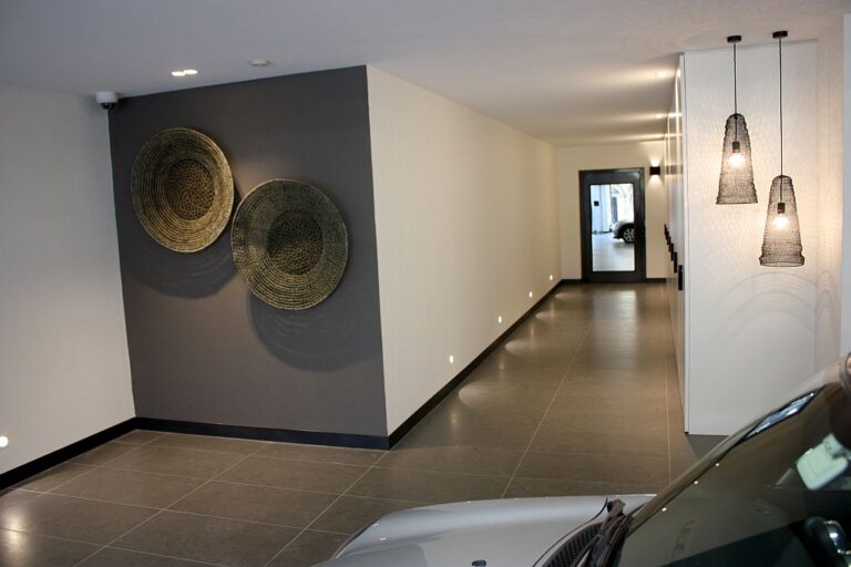 Long corridor with a dark grey feature wall, woven wall plates and pendant lights