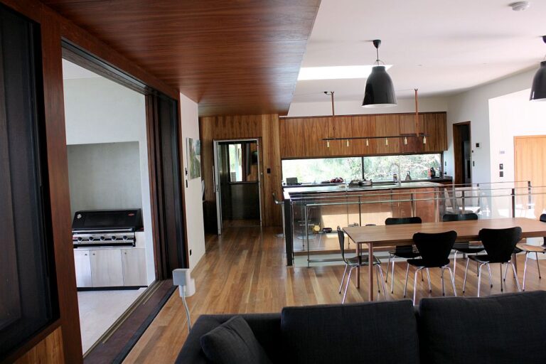 Open plan kitchen, dining and lounge with a timber ceiling and sliding glass doors