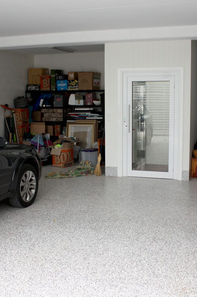 Garage with storage shelves and the white ElfoLift door with a glass panel