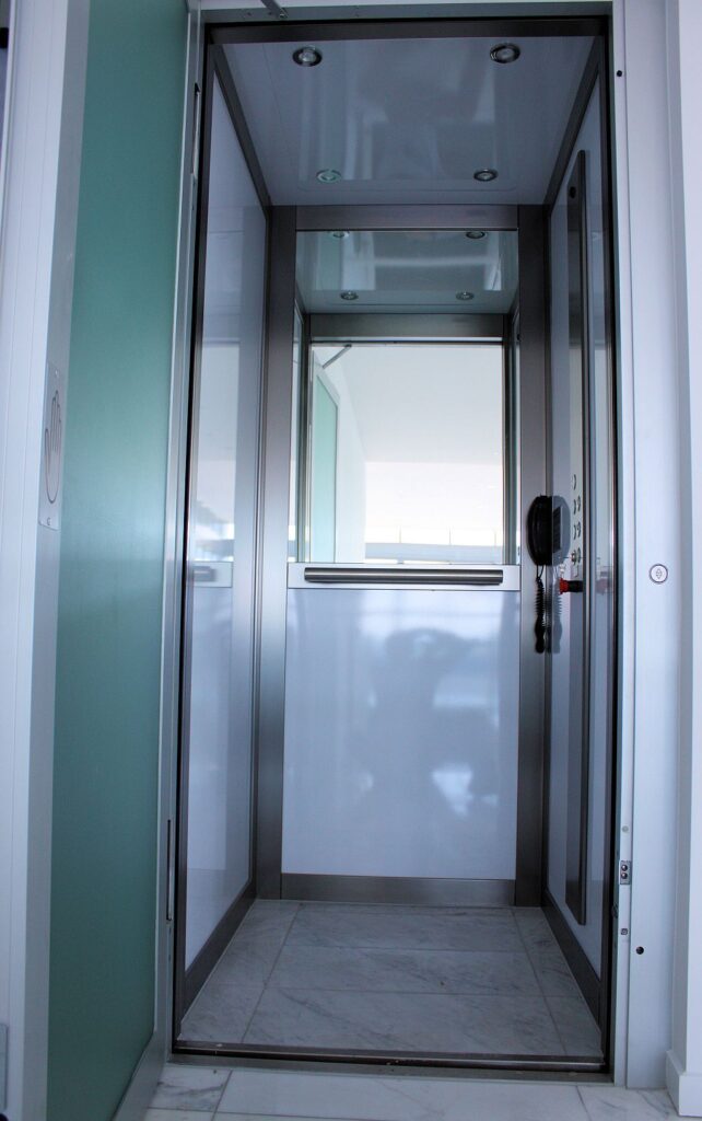 Inside the finished ElfoLift cabin at a Sapphire Towers penthouse, with white gloss panels, a stainless steel frame and a half-height mirror