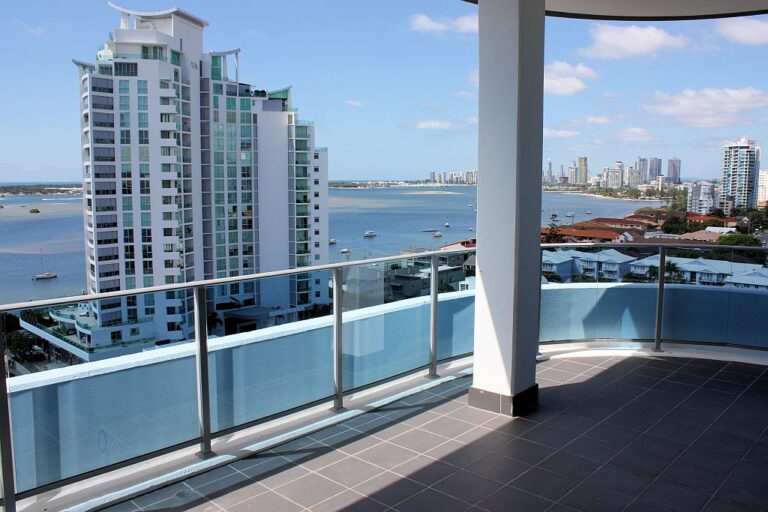 Balcony with a glass balustrade overlooking the Broadwater and a tall tower