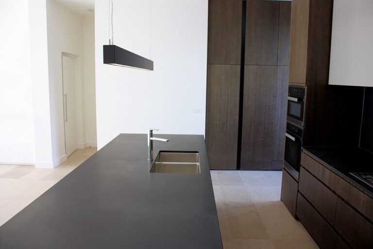 Open-plan kitchen with a dark island and timber cabinetry in a Brighton townhouse