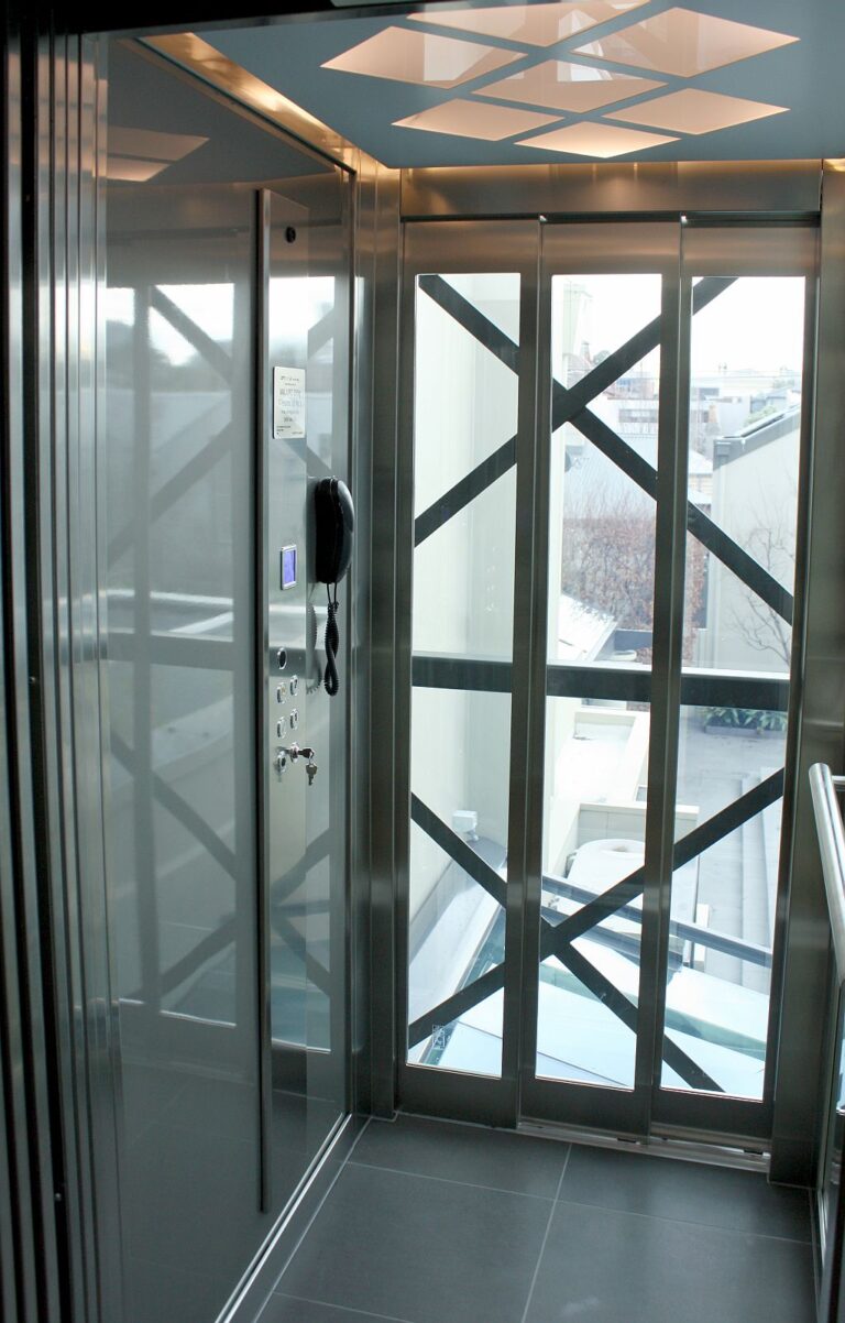 Inside the ElfoLift 2 with a clear glass wall opening to the landscaped backyard view
