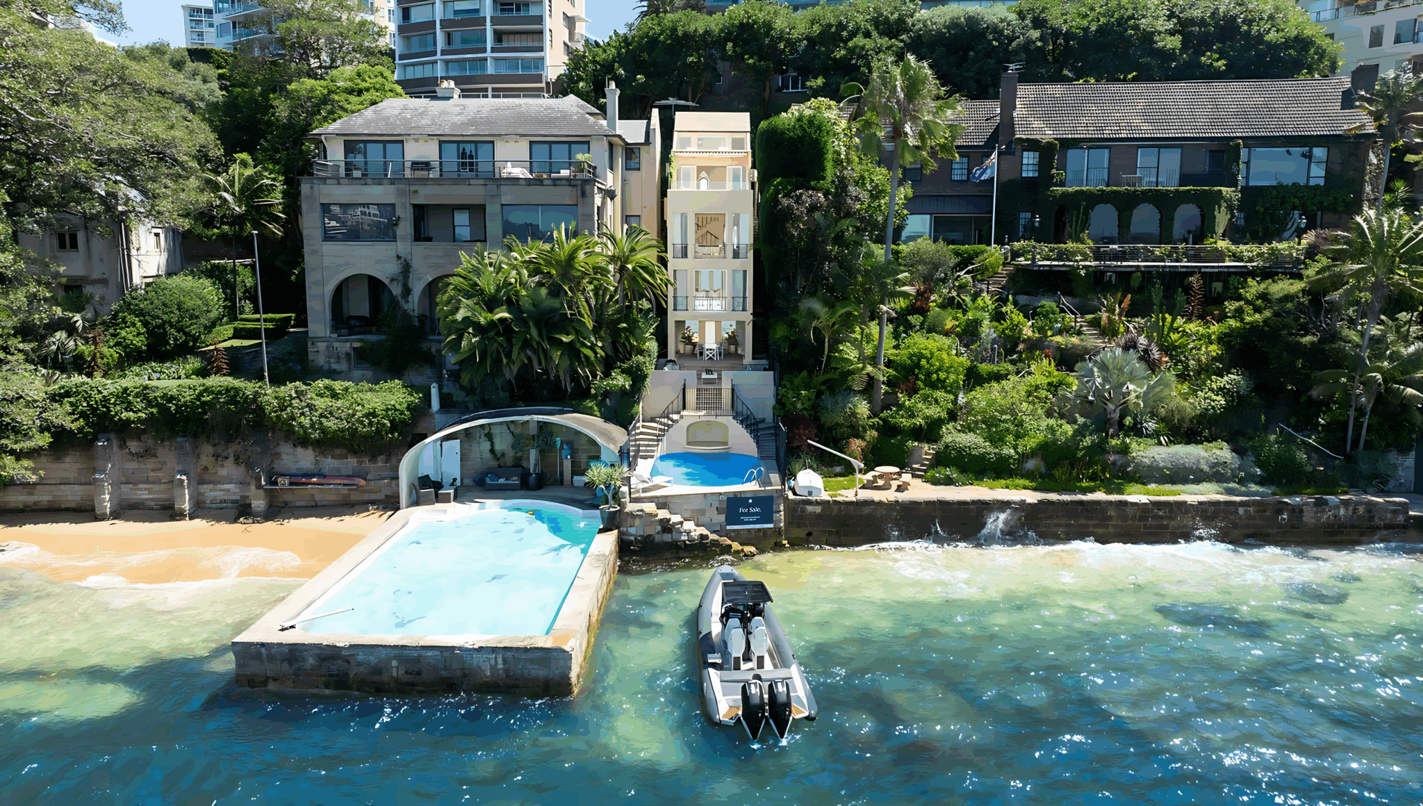Aerial view of the slim Darling Point waterfront home beside the harbour, with its pool, sea wall and a boat at the water's edge