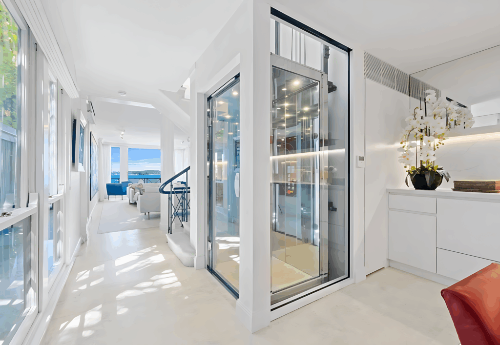 Glass-walled lift integrated into luxury home interior corridor