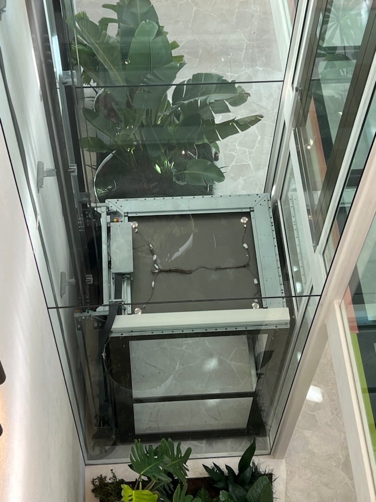 Lift Shop A Series glass elevator in The Solstice, connecting three levels with frameless doors.