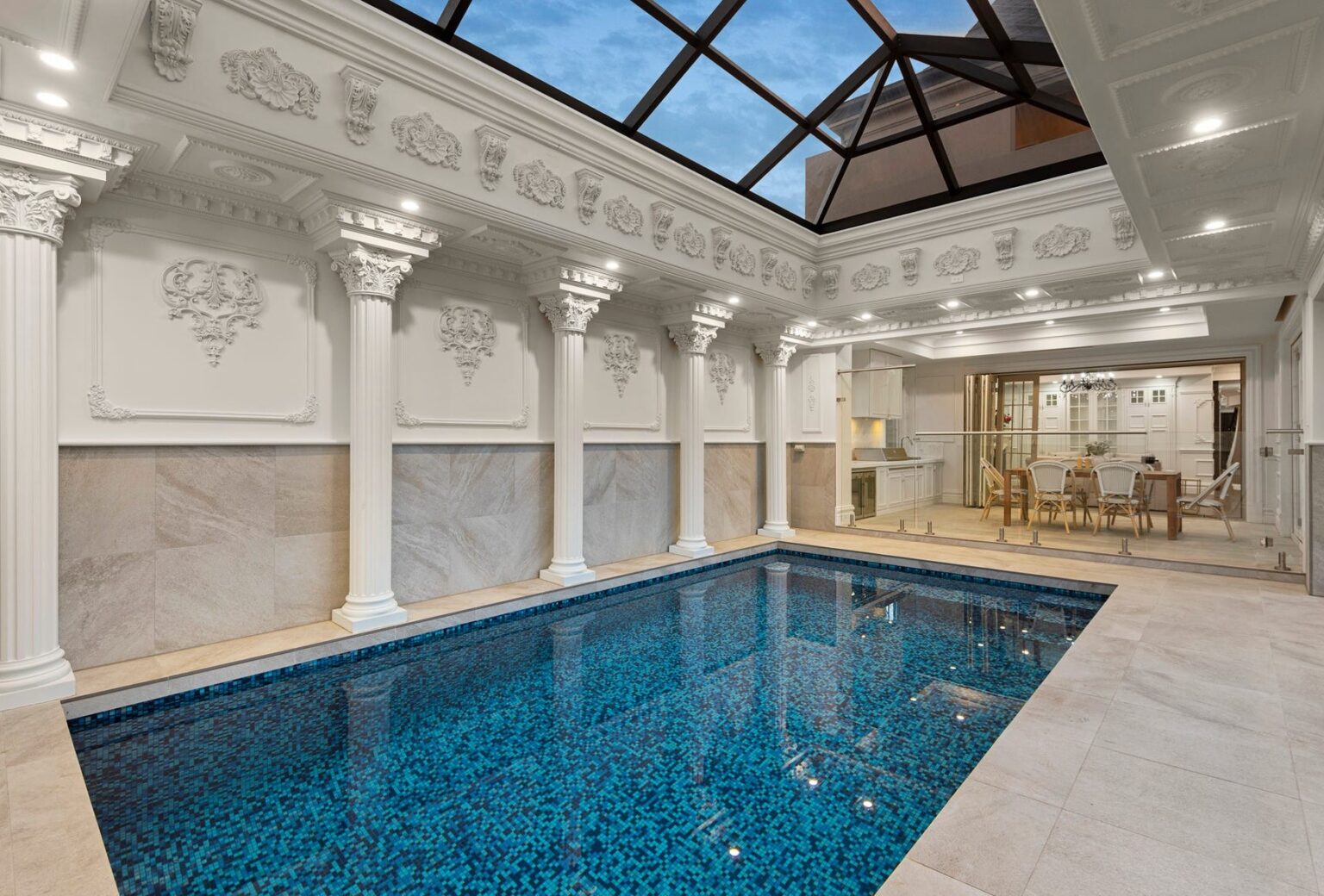 Indoor pool with white columns, plaster cornices and a glass roof in a Balwyn luxury home