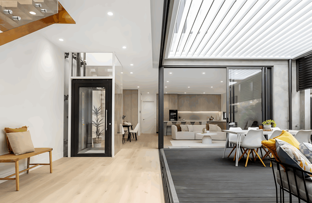 Black-framed glass Lift Shop home lift in a modern open-plan living, dining and kitchen space