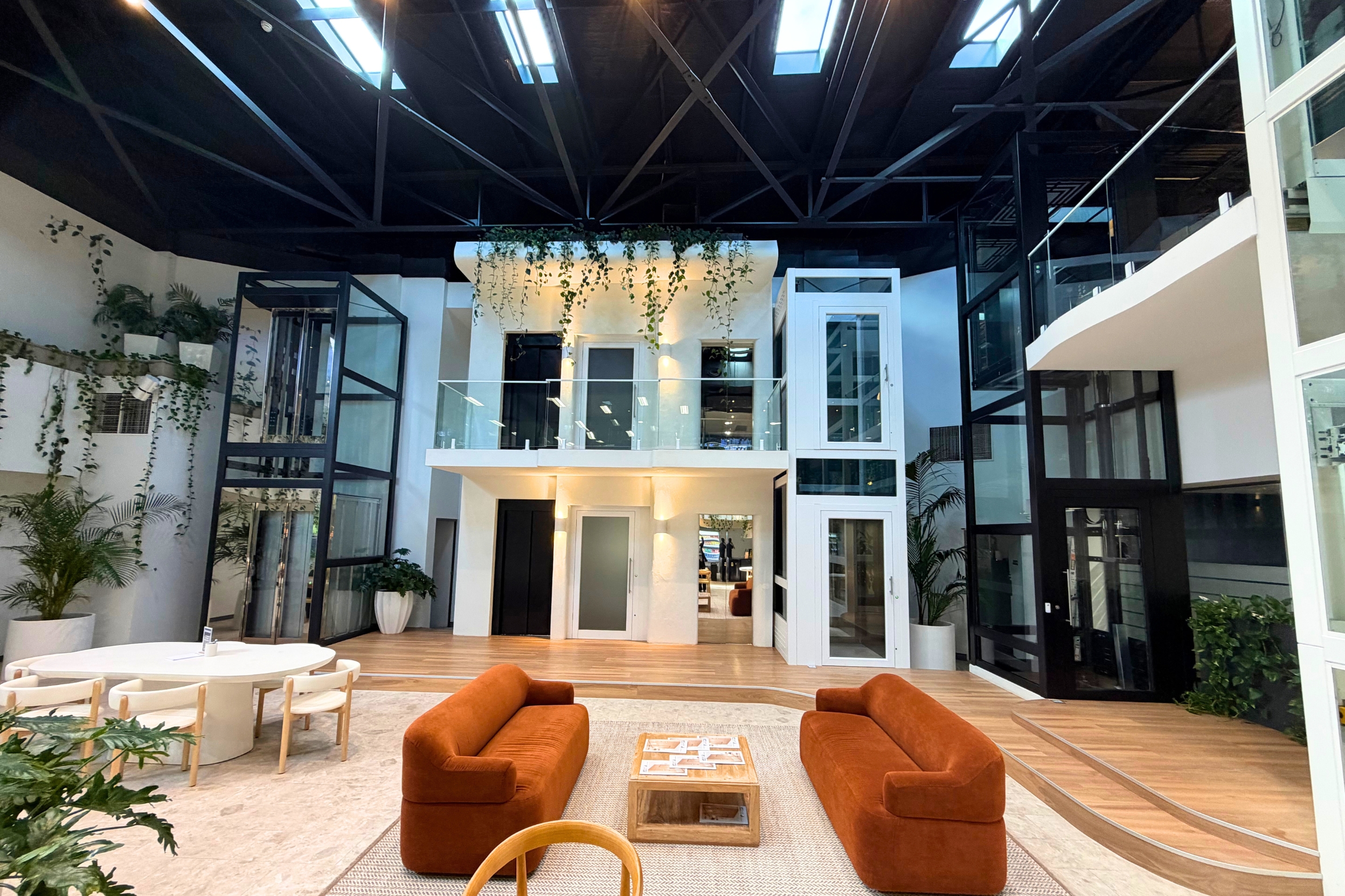 Lift Shop showroom with several working home lifts on display among greenery, timber floors and orange sofas