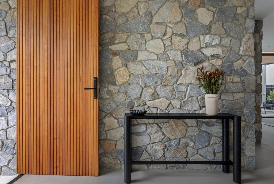 Natural stone feature wall and timber entry detailing in luxury Kew residence